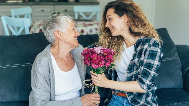 Una joven regala flores a su abuela.