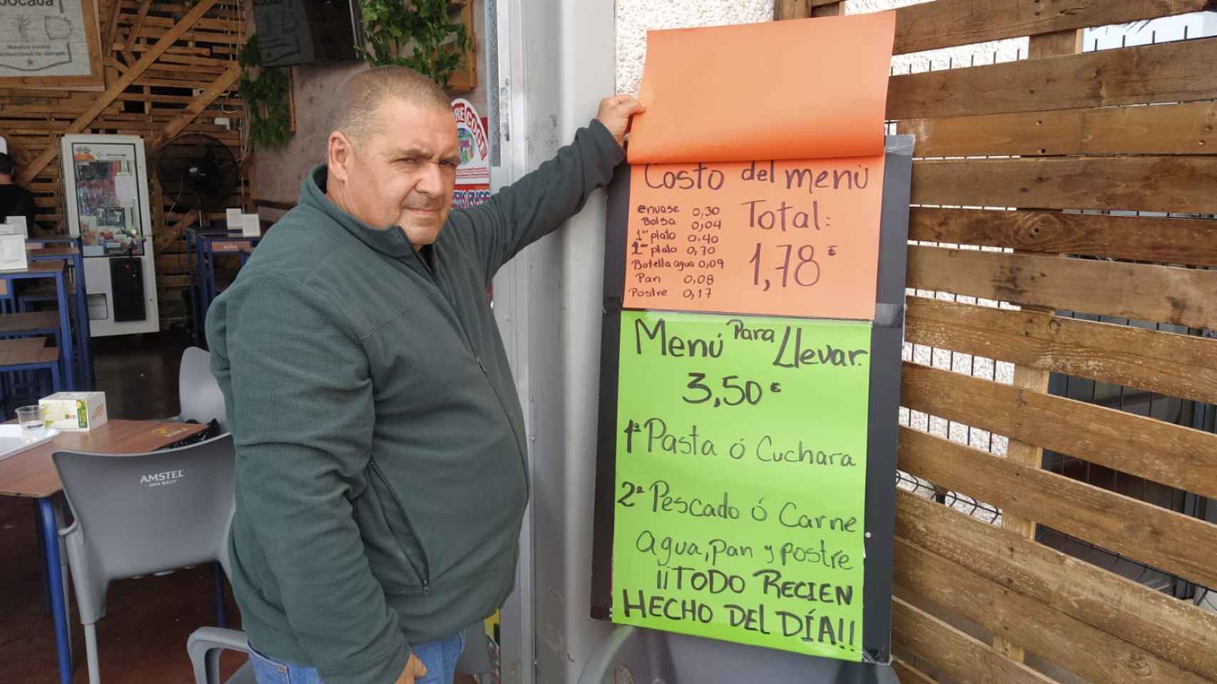 Carlos Moreno, enseñando el cartel que asegura que el costo del menú de 3,50 euros es de 1,78 euros.