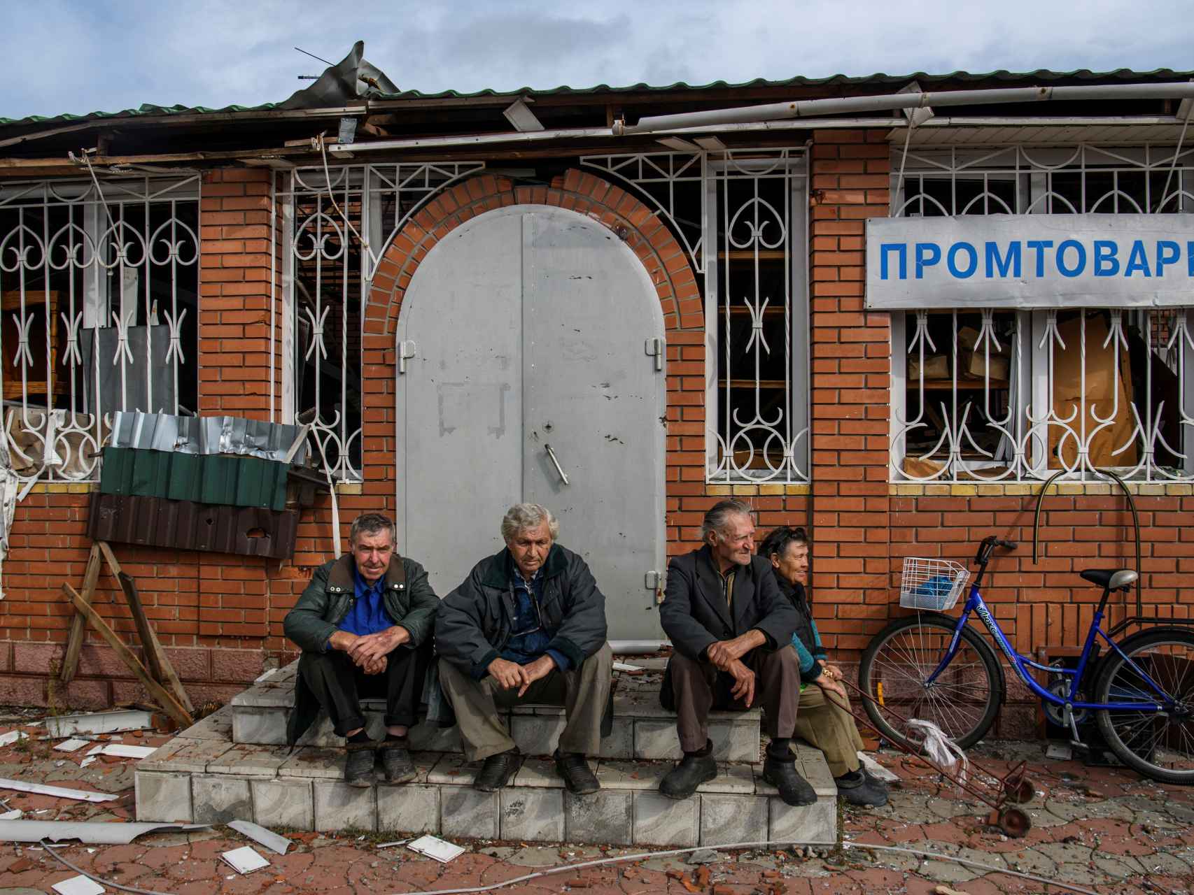 Cuatro personas se reúnen a las puertas de una tienda en el pueblo de Yatskivka, Donetsk..