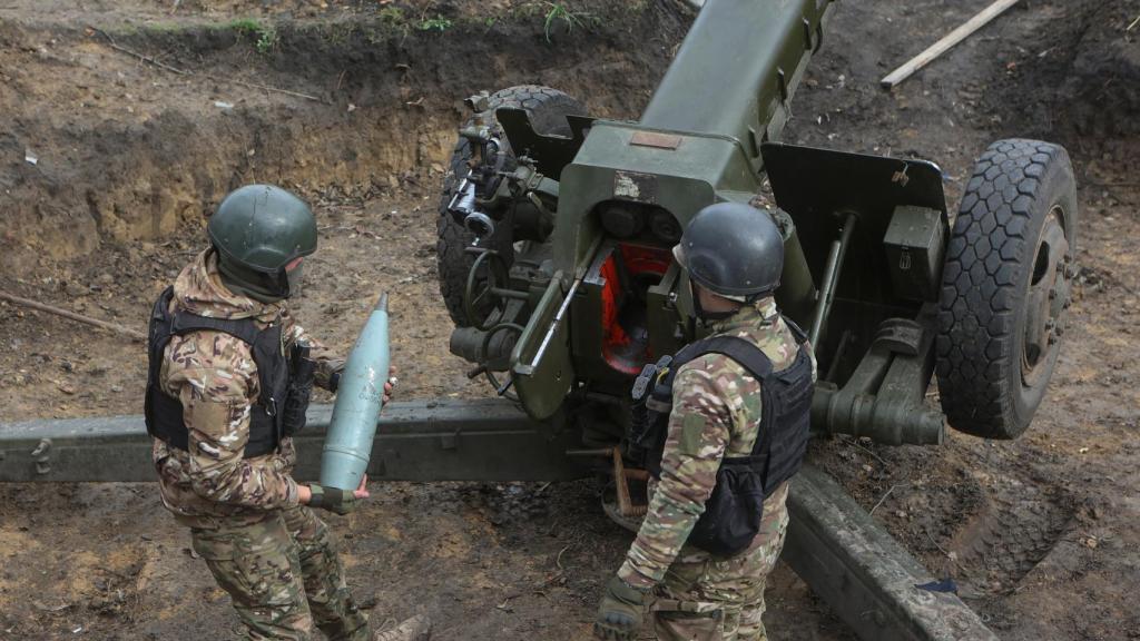 Miembros de la Guardia Nacional de Ucrania cargan un proyectil.