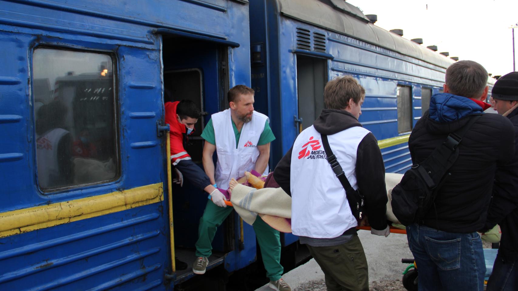 Un paciente siendo trasladado a uno de los trenes medicalizados.