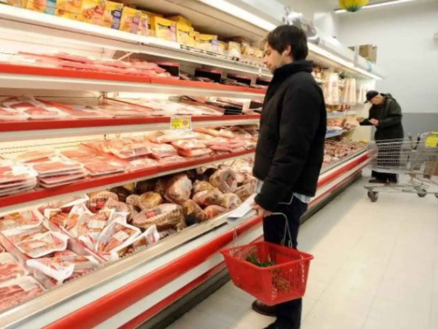 Un hombre compra carne en un supermercado.