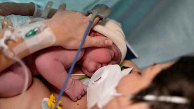 Un mujer con su hijo recién nacido por cesárea.