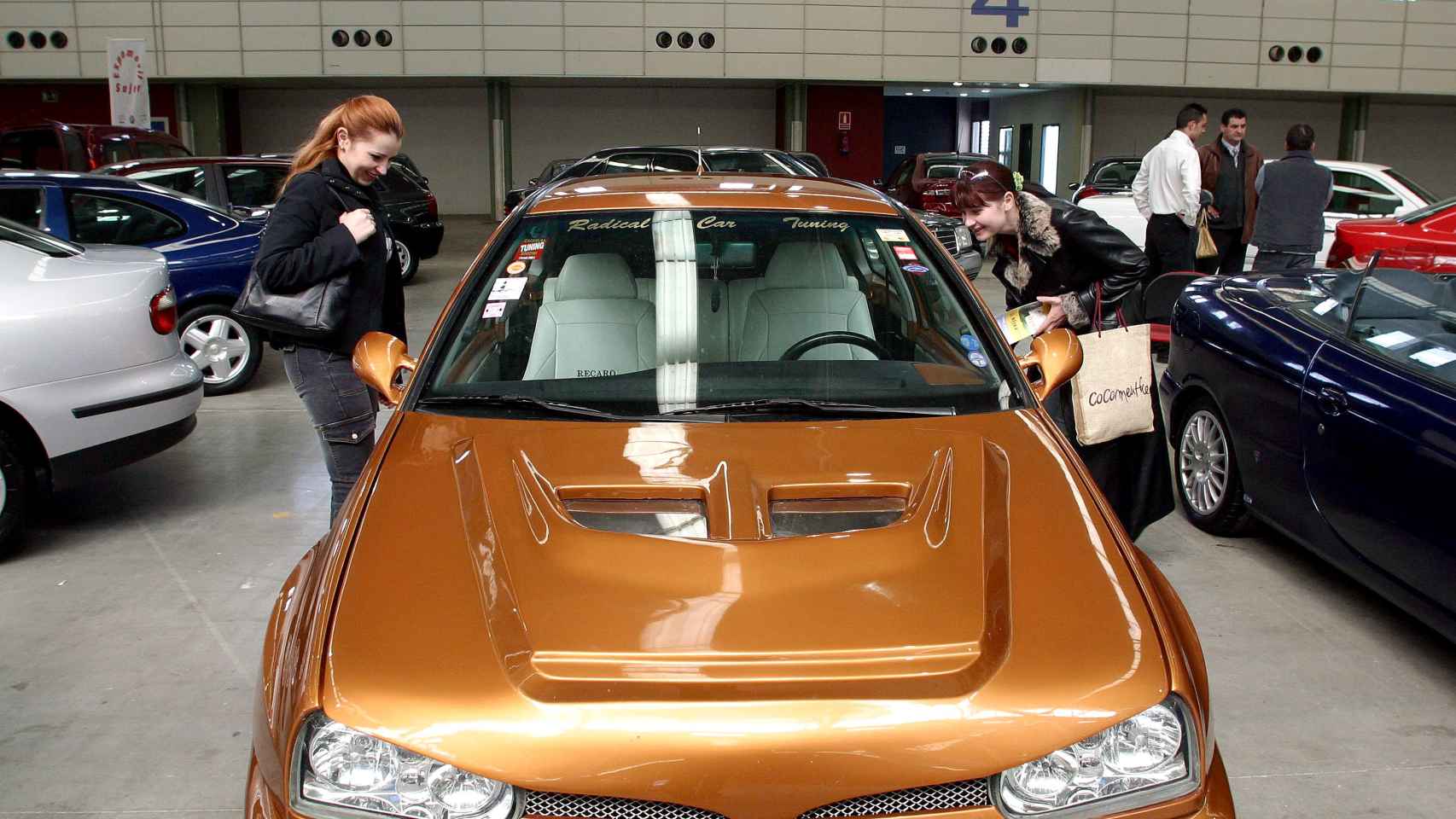 Dos mujeres se interesan por un coche de segunda mano en una Feria de Vehículos de Ocasión de Valladolid