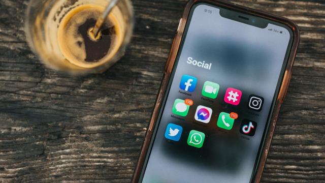 Smartphone con las aplicaciones de Twitter, Facebook, WhatsApp, Instagram o TikTok, entre otras, en la pantalla junto a una taza de café.