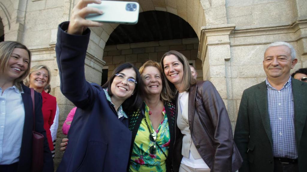 La ministra de Sanidad, Carolina Darias y la alcaldesa de Lugo, Lara Méndez, se hacen un selfie con una mujer.
