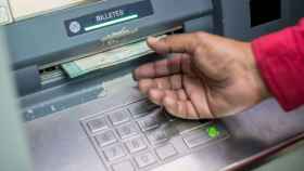 Un usuario saca dinero de un cajero automático.
