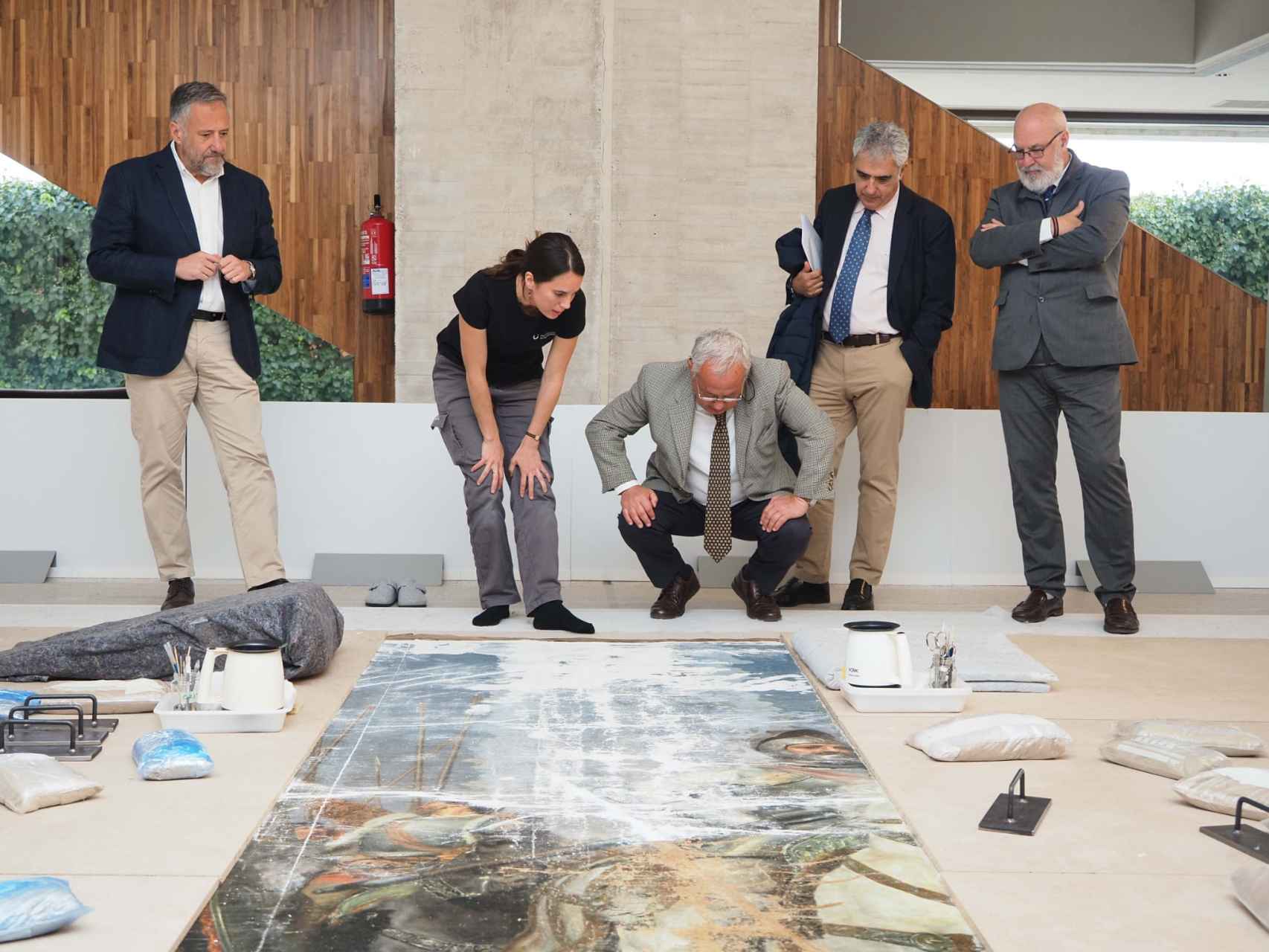 El presidente de las Cortes, Carlos Pollán, y el consejero de Cultura, Gonzalo Santonja, observan el estado de los trabajos de restauración de la obra 'Los Comuneros de Castilla', este lunes en las Cortes.