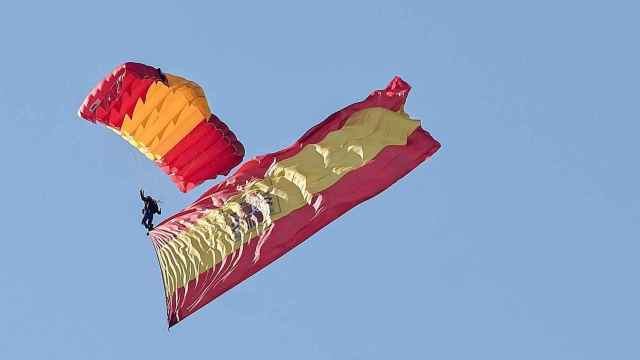 Un paracaidista porta banderas de España en el desfile militar de las Fuerzas Armadas de 2022.