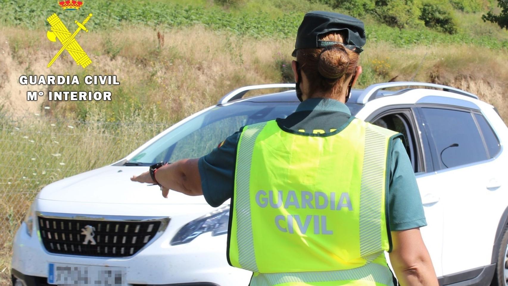 Un agente de la Guardia Civil detiene un vehículo