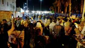 Un grupo de personas espera a allegados que cruzan la frontera en Melilla.