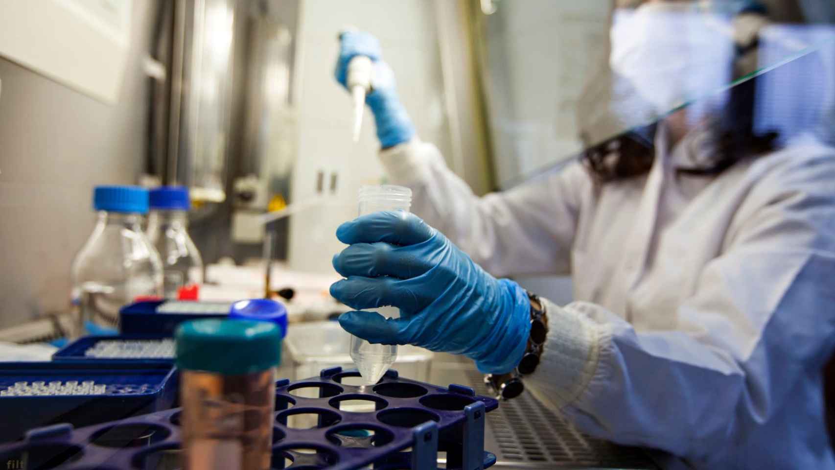 Una científica manejando una pipeta en un laboratorio.
