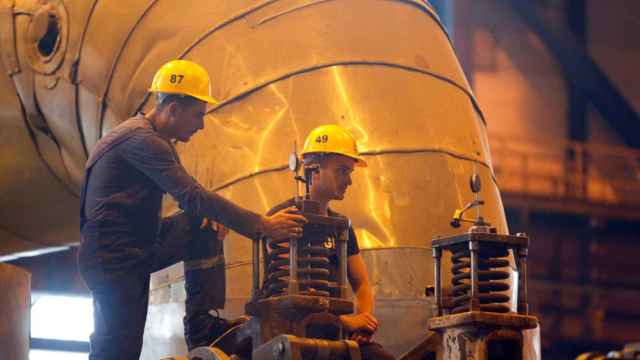Dos trabajadores realizan el mantenimiento de una turbina de carbón  en Macedonia del Norte