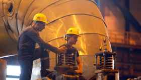 Dos trabajadores realizan el mantenimiento de una turbina de carbón  en Macedonia del Norte
