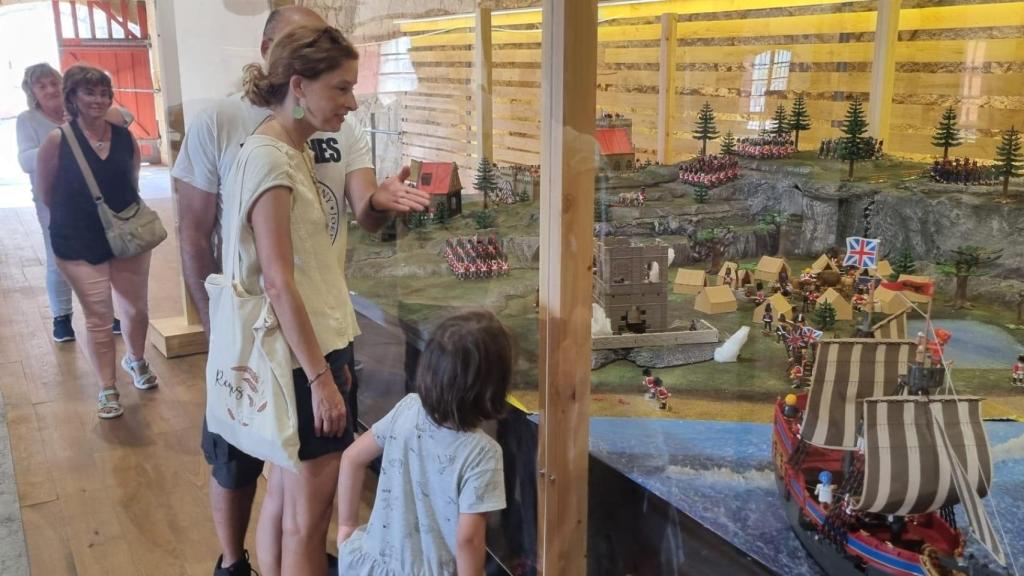 Una familia contempla la muestra en la sala Cureñas del Castillo de San Felipe