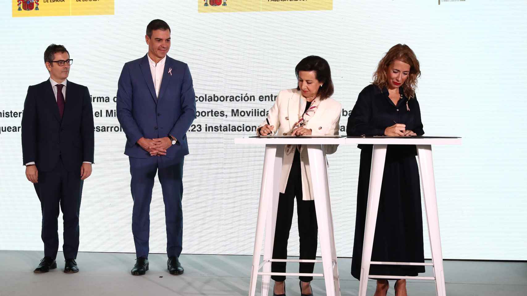 La ministra de Defensa, Margarita Robles, y la ministra de Transportes, Movilidad y Agenda Urbana, Raquel Sánchez, firman el protocolo en presencia del presidente del Gobierno, Pedro Sánchez y del ministro Félix Bolaños.