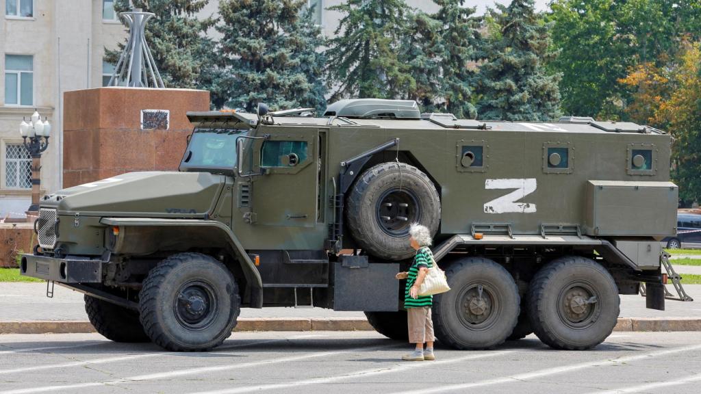 Una mujer junto a un tanque ruso en Jersón.