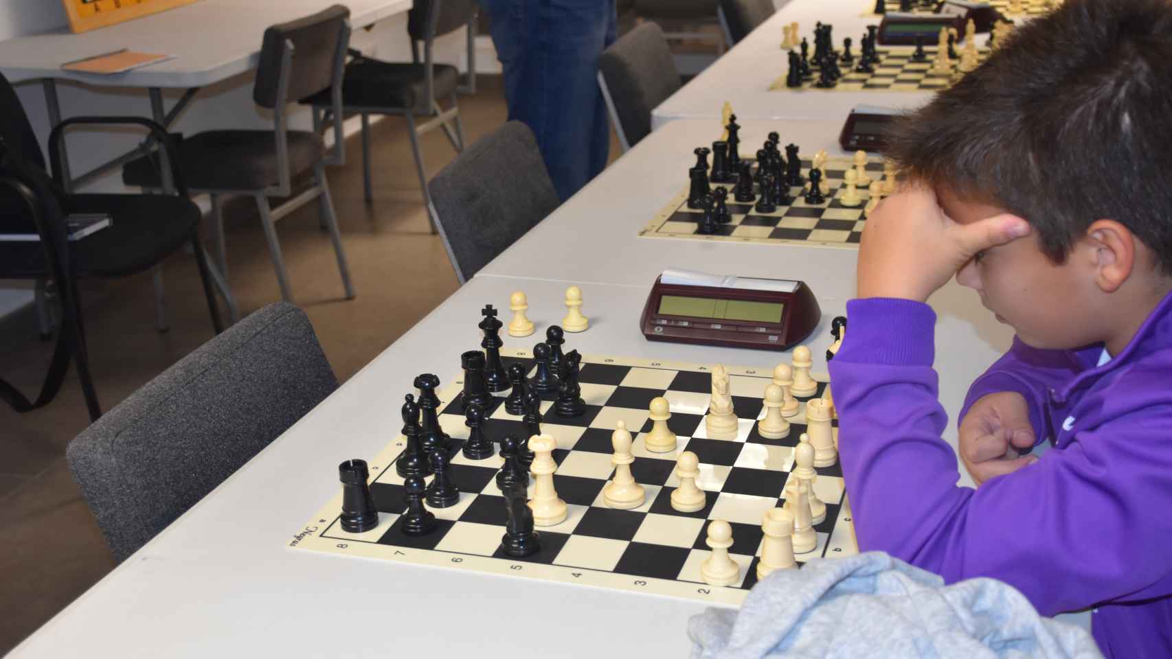 Uno de los niños del club concentrado en el tablero de ajedrez
