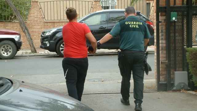 Uno de los detenidos camina esposado junto a un agente de la Guardia Civil.