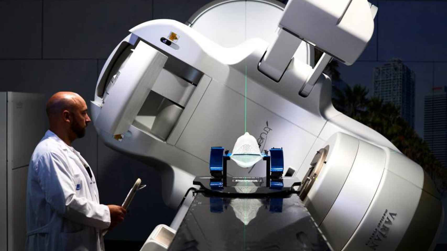 Un sanitario manejando una máquina de radioterapia.