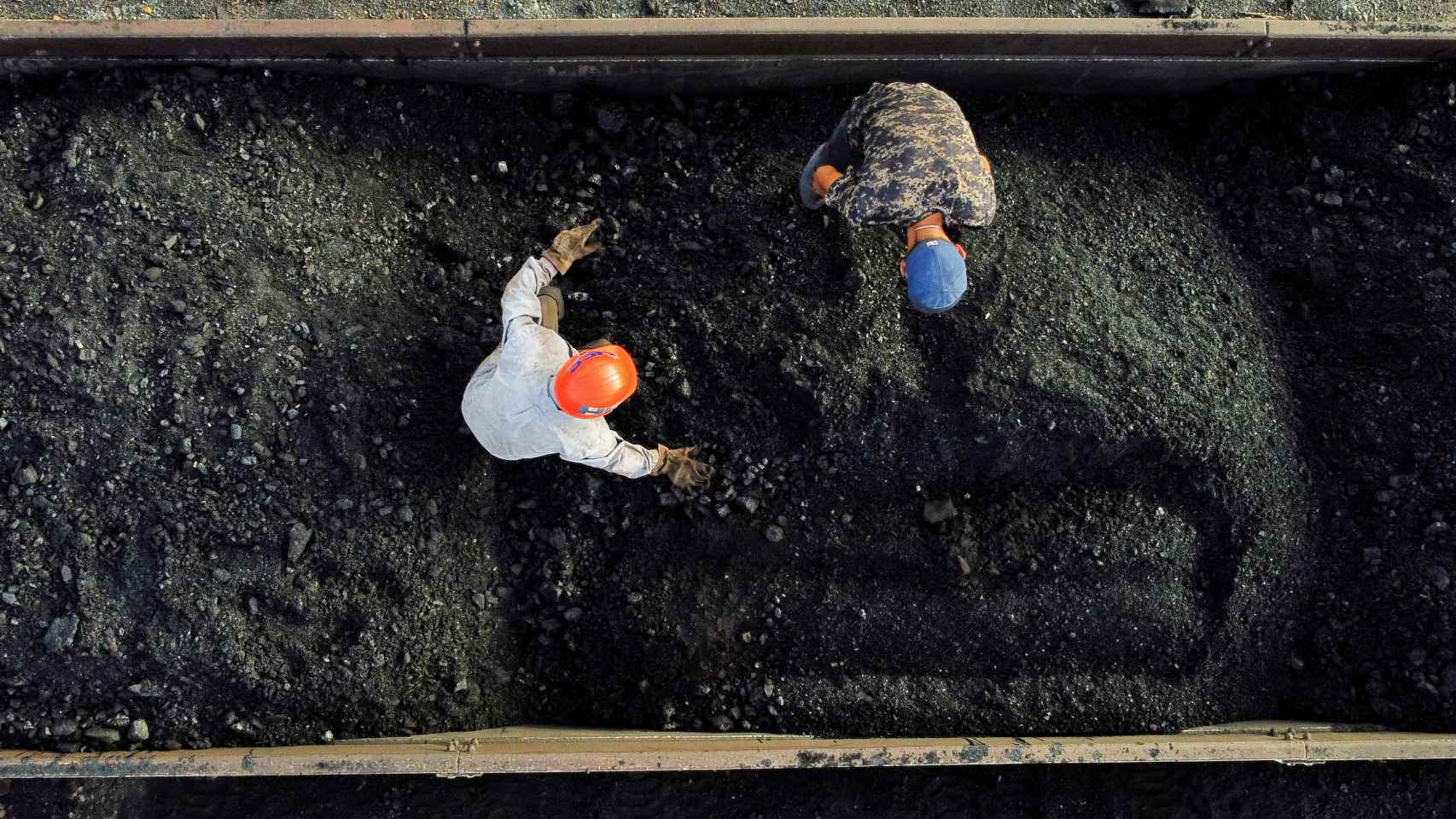 Dos mineros separan piedras del carbón antes de transportarlo a una mina, en México.