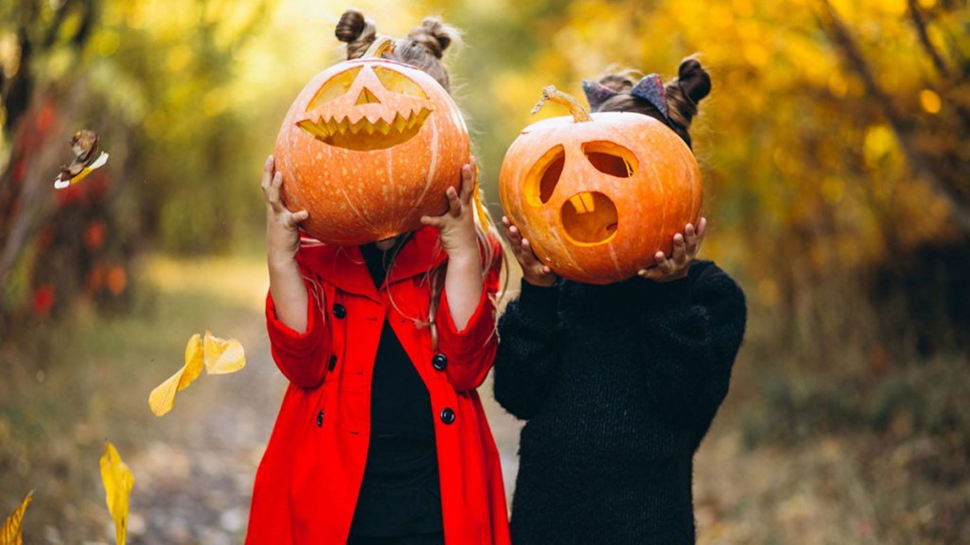 Dos niñas muestran sus calabazas de Halloween.