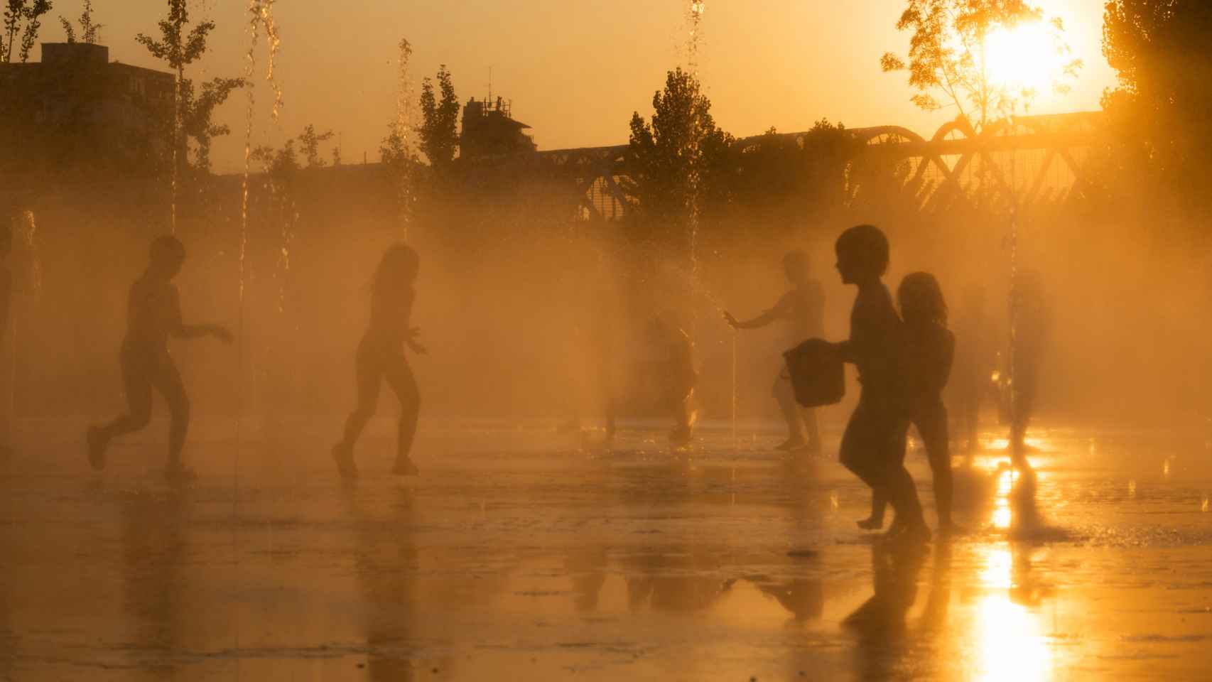 Varios niños jugando en una fuente de Madrid durante una ola de calor.