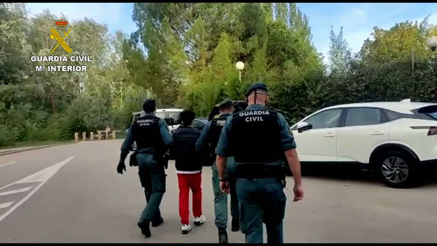 Los agentes de la Guardia Civil se llevan a uno de los detenidos.