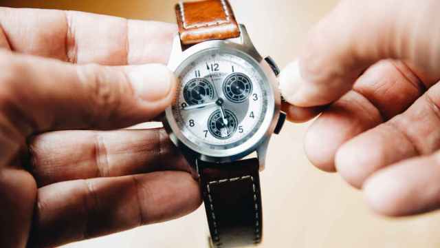 Una persona cambia la hora en su reloj.
