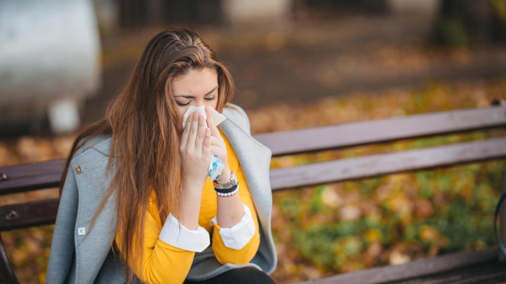 Una mujer resfriada y con gripe.