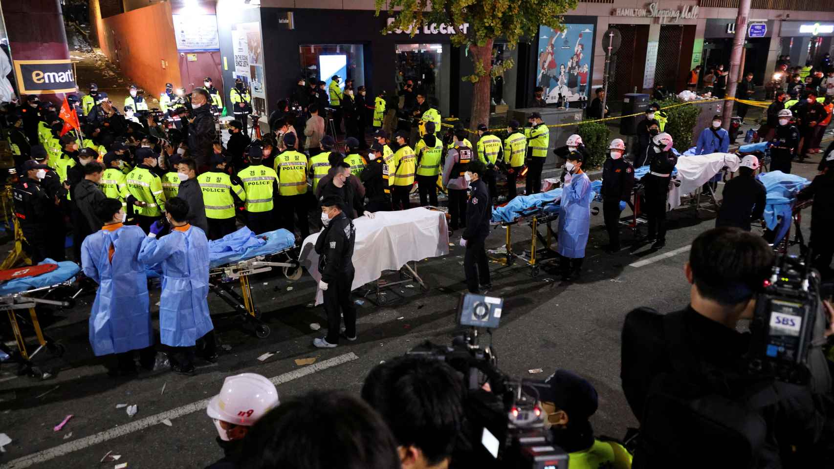 Una fila de camillas y de sanitarios atienden a los heridos en una calle de Seúl tras la tragedia de este sábado.