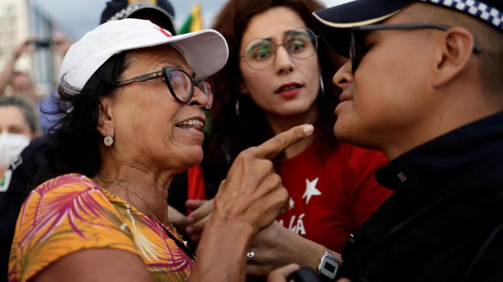 Una activista pro Lula se encara con un Policía de Brasil durante un acto de la campaña electoral