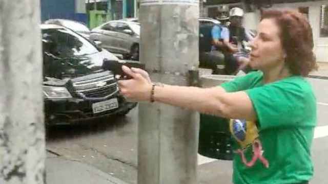 La diputada brasileña Carla Zambelli apunta con una pistola, en las calles de Sao Paulo.