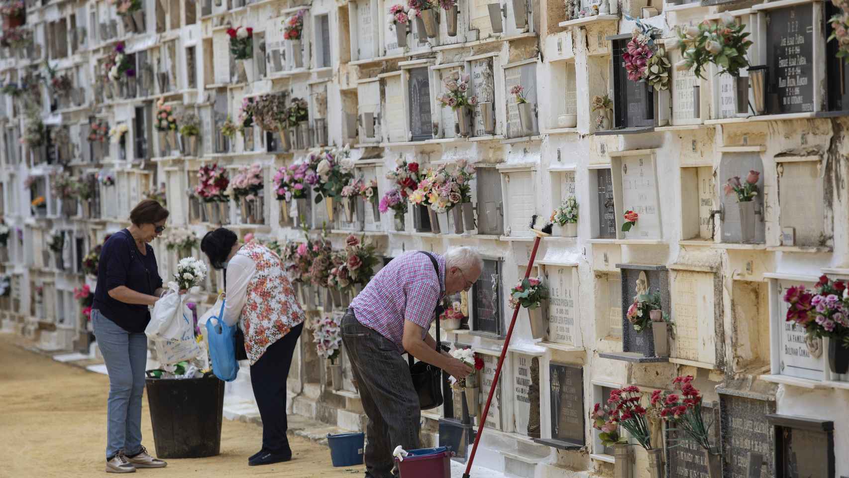 Varias personas arreglan las sepulturas del cementerio de San Fernando (Sevilla)