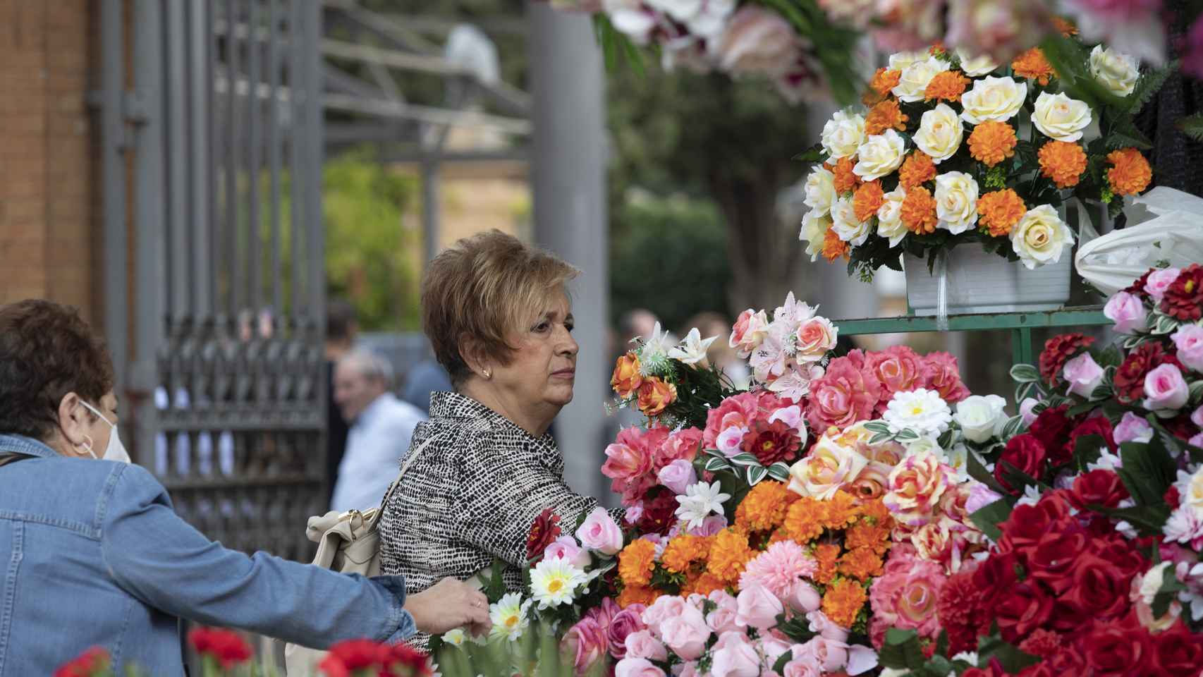 Varias personas compran flores para recordar a quienes ya no están en el Día de Todos los Santos.