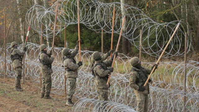 Soldados polacos instalan alambre de espino a lo largo de la frontera polaca con el exclave ruso de Kaliningrado, cerca del pueblo de Zerdziny, en el noreste de Polonia.