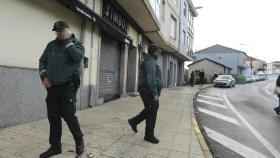Dos Guardias Civiles vigilan en la calle Cardenal Quiroga, donde se produjeron los disparos a un vecino en Maceda (Ourense)