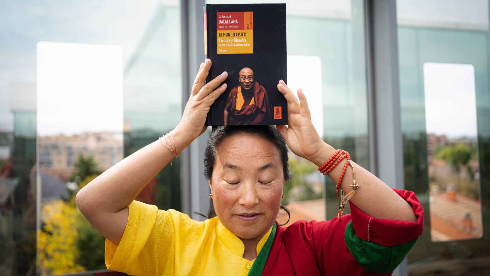 Khadro-la sostiene un libro del Dalái Lama sobre su cabeza
