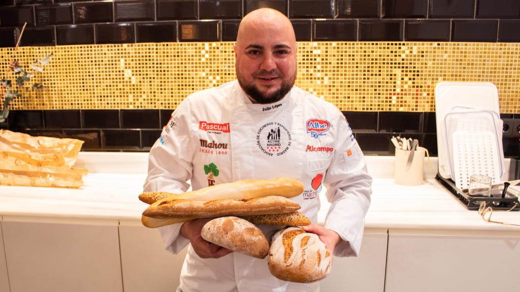 El maestro panadero Julio López, sujetando cinco panes.