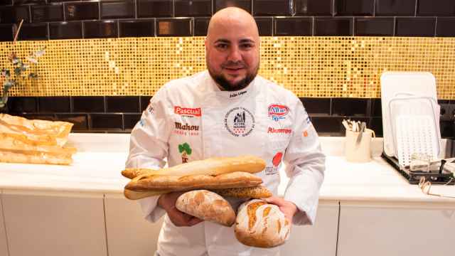 El maestro panadero Julio López, sujetando cinco panes elaborados y vendidos en Lidl.