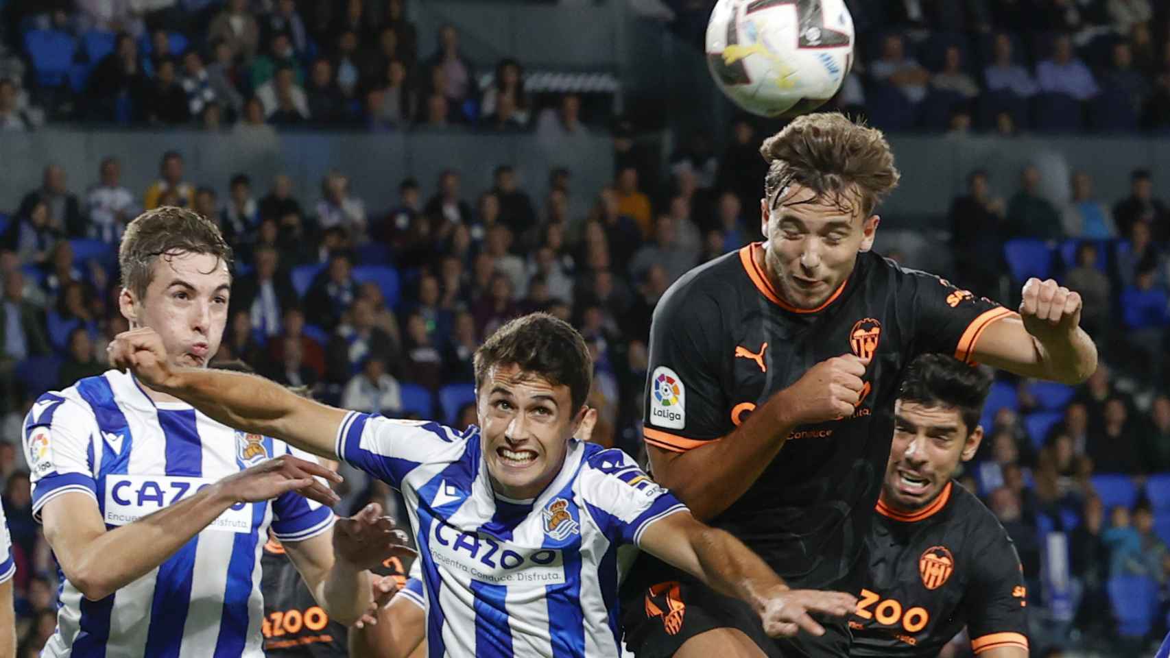 Los jugadores de la Real Sociedad y el Valencia luchan un balón aéreo.