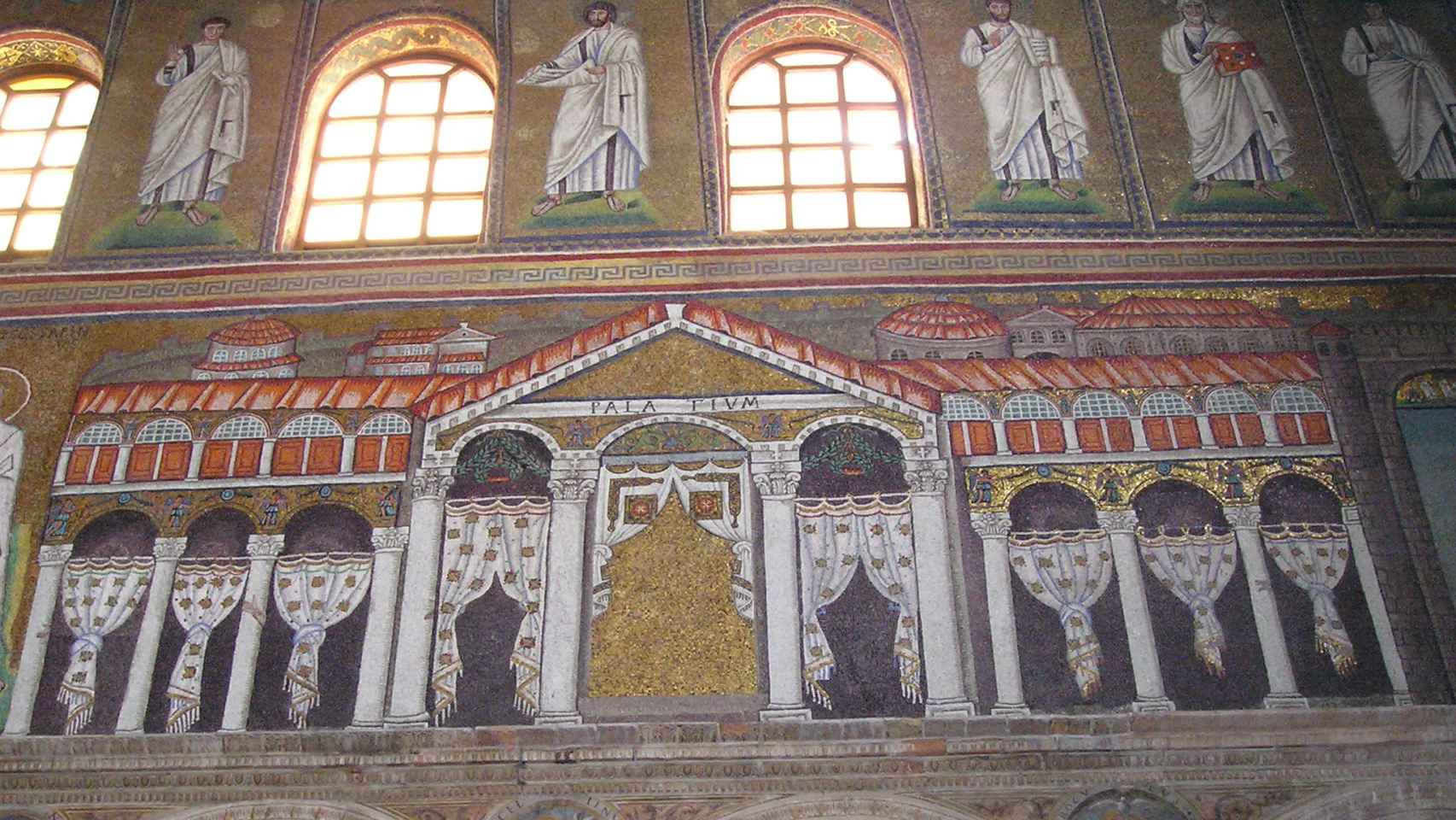 El mosaico del 'palatium' con la ciudad amurallada d Rávena, detrás, en el extremo oeste de San Apolinar el Nuevo. Originalmente, Teodorico aparecía entronizado bajo el arco central.