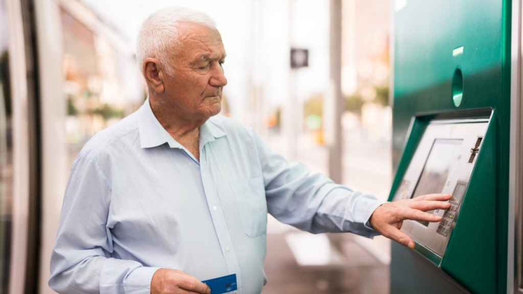 Un jubilado sacando dinero de un cajero automático.