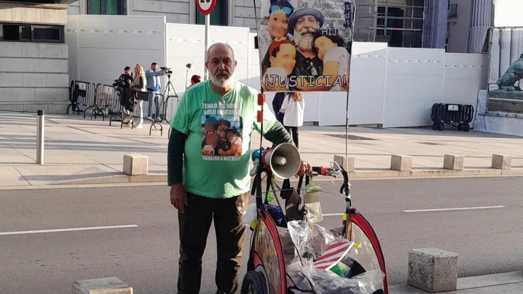 Luis Gómez Hidalgo, protestando ante el Congreso junto al carro con el que ha andado dos veces a Madrid desde Algeciras.