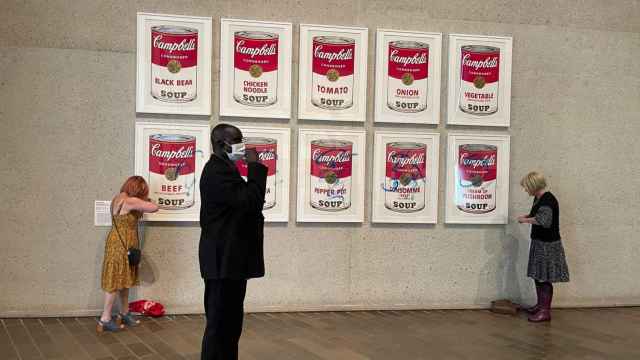 Dos activistas pegándose y pintando las icónicas obras de Warhol. Foto: Efe / Stop Fossil Fuel Subsidies