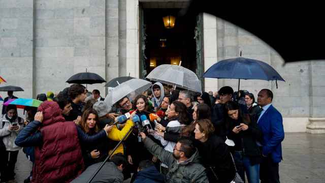 Isabel Díaz Ayuso atiende a los periodistas, este miércoles bajo la lluvia, ante la puerta de la Catedral de la Almudena.