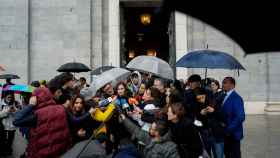 Isabel Díaz Ayuso atiende a los periodistas, este miércoles bajo la lluvia, ante la puerta de la Catedral de la Almudena.