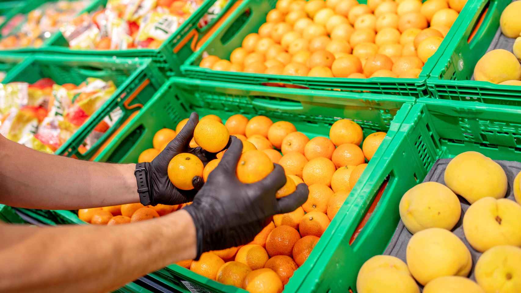 Un trabajador de Mercadona cogiendo las mandarinas que comercia la superficie.