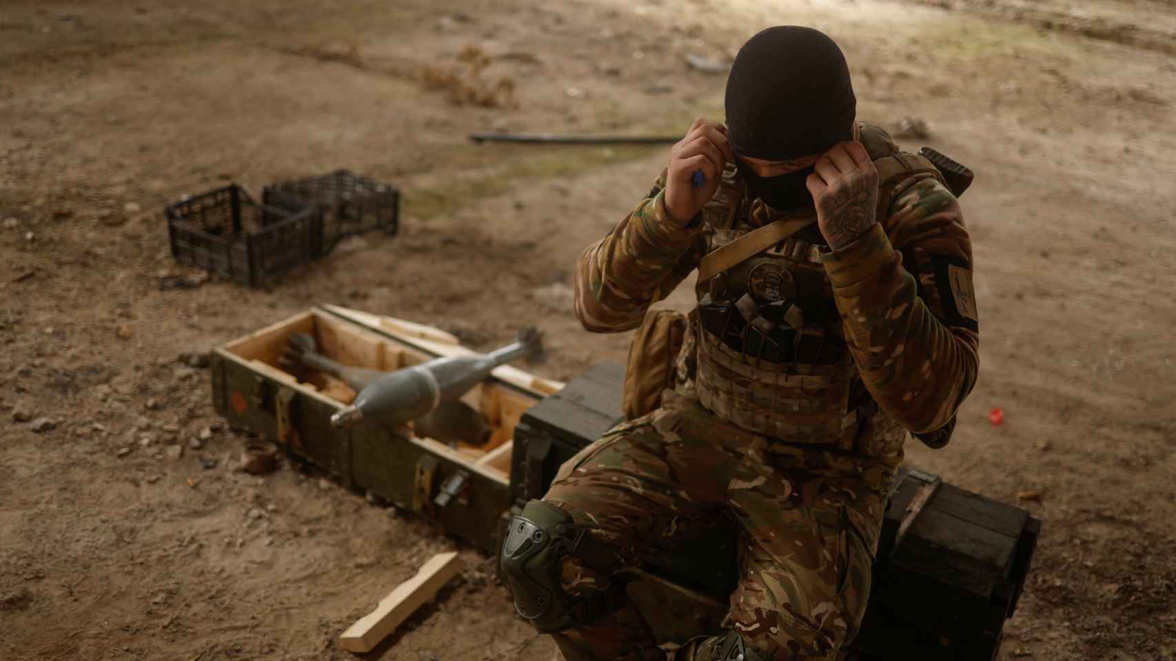 Soldado ucraniano se sienta en proyectiles de mortero rusos capturados en el pueblo de Blahodatne en la región de Kherson
