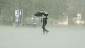 Un hombre camina bajo la intensa lluvia este viernes en Valencia.